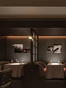 A minimalist restaurant interior with modern design elements and neutral color palette, featuring sleek seating, elegant tabl