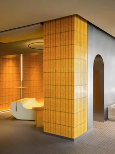 A modern restaurant interior with yellow tiled walls and a sleek seating area.
