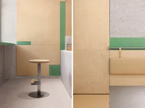An office interior with wooden panels, concrete accents, and a small round table.