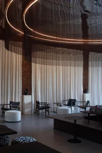 Modern hotel lounge area with soft textiles and concrete elements