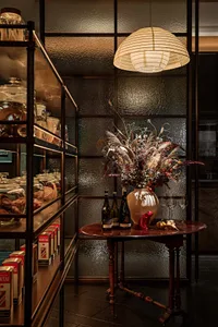 A modern retail storefront with wooden finishes and a vase of flowers.