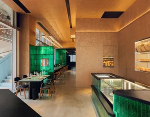 Modern cafe interior with green tiles and concrete walls and floors