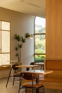 Modern cafe interior with wooden furniture and green plants