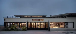 Modern commercial storefront with glass walls and interior lighting.