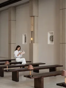 A modern lobby interior with concrete walls and glass accents.
