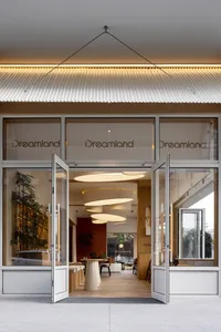 A modern retail storefront featuring glass panels and modern lighting fixtures.
