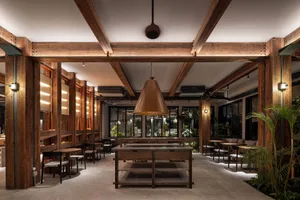 A warm and inviting cafeteria interior with wooden walls and fixtures, featuring a central table and seating arrangements.