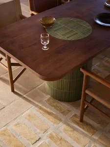 A modern dining room featuring wooden furniture and a glass drink container.