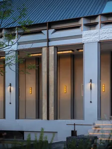 Modern residential entryway featuring a concrete facade and contemporary lighting fixtures.