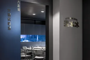 Modern restaurant with sleek design, glass cabinets, and silver chairs.