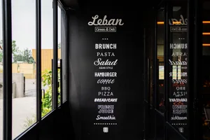 A black menu board featuring a list of food items in white text, including brunch, pasta, salad, hamburger, coffee, BBQ, pizz