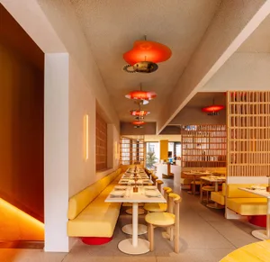 A modern restaurant interior with yellow leather seating and minimalist design.
