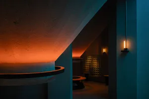 A modern lobby interior featuring exposed concrete walls and a warm, rugged lighting ambiance.