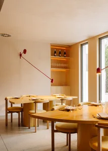 現代餐廳室內，搭配木質桌椅與混凝土地板及牆面。