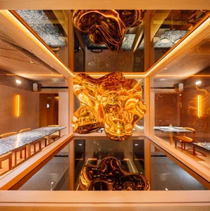 Modern restaurant interior featuring metallic sculptures hanging from the ceiling.