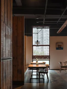 Industrial-style restaurant interior with wooden tables and chairs.