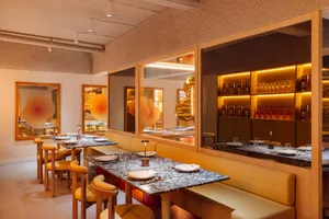 A modern restaurant interior featuring marble, concrete, and cork materials.