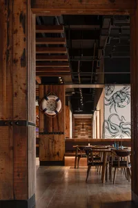 Interior of a restaurant with a nautical theme featuring wooden walls, tables, and chairs.