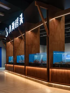 A spacious seafood market featuring a large, modern interior with wood paneling and bright, illuminated signage.