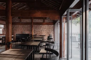 Industrial-themed restaurant featuring exposed brick walls and wooden furniture.