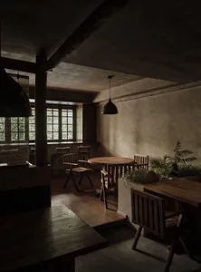Modern restaurant interior featuring wooden tables and chairs with a warm, industrial ambiance