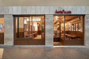 A cozy Italian trattoria with concrete walls and wooden furnishings.