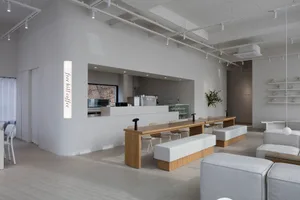 A minimalist coffee shop featuring wooden and concrete materials.