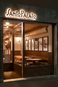 Modern coffee shop interior with wooden elements and framed art hanging on the wall.
