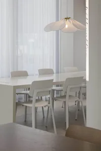 Modern dining room with white furniture and light-colored curtains.