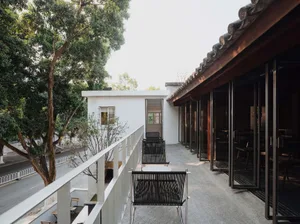 A modern restaurant terrace featuring concrete flooring and a minimalist design.