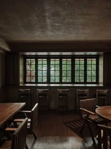 工業風主題的餐酒吧，搭配質樸木製桌椅、金屬點綴，以及一扇可眺望樹景的大窗。
