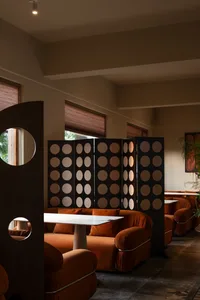 A modern cafe interior with textured plywood panels, comfortable seating, and a cozy ambiance.