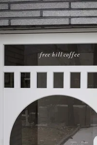 A glass storefront sign with the text 'free hill coffee'.