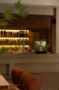 An industrial-style bar counter with metallic finishes and illuminated shelves.