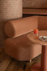 A cozy cafe with comfortable seating, a marble round table, and wooden accents.