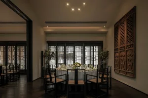 A modern restaurant interior featuring wooden furniture, glass walls, and metal accents.