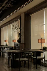 A modern cafe interior featuring wooden furniture, fabric seating, and metal accents.