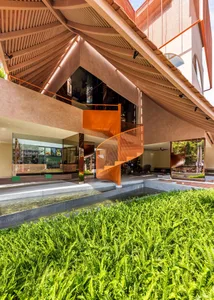 A modern interior featuring a metal spiral staircase and lush greenery.