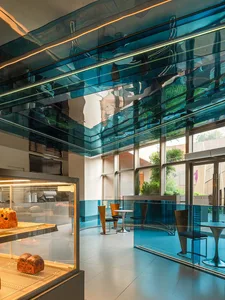 A modern, minimalist coffee shop with a glass ceiling, featuring sleek furniture and a bright, open design.