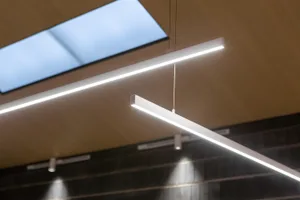 A modern interior with sleek, metallic pendant lights hanging from the ceiling.