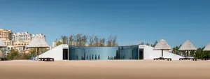 Modern glass house on a sandy beach