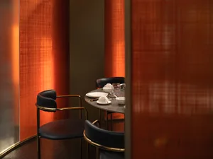 A sleek, metallic restaurant interior with seating for four.