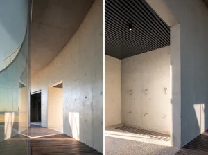 The interior of a modern architectural space featuring concrete walls and floors.