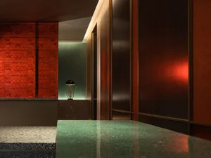 Modern entrance lobby featuring metallic textured walls and ceiling with green accents.