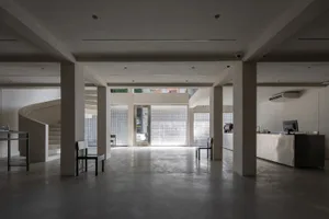 A minimalist coffee shop interior with concrete flooring and glass block walls.