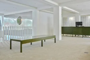 A modern office space featuring a minimalist metal desk and glass elements.