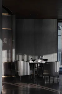 Modern dining room featuring metal chairs, leather seating, and wooden accents.