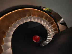 A sleek, modern, minimalist metal staircase with curved steps.