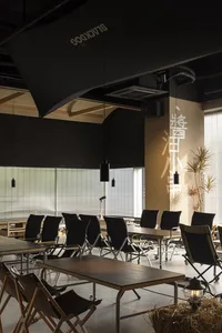 A minimalist cafe interior with wooden tables and metal chairs.
