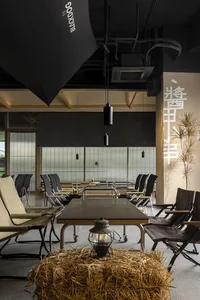 Industrial-themed restaurant interior with metal tables and chairs, natural light, and minimalist design.